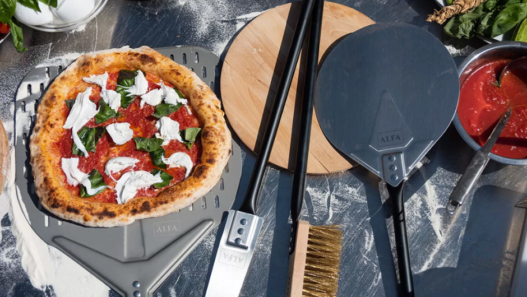 Wooden Acacia pizza peel on a kitchen counter, perfect for sliding pizzas in and out of the oven.
