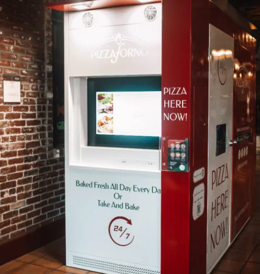 Red-and-white PizzaForno vending machine dispensing a freshly baked 12-inch pizza in California.