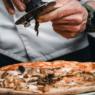 Chef slicing the world’s most expensive pizza topped with wild luxury ingredients, showcased in an upscale setting.