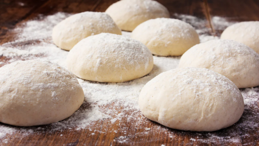Eight individually frozen 240 g pizza dough balls arranged neatly in clear packaging.