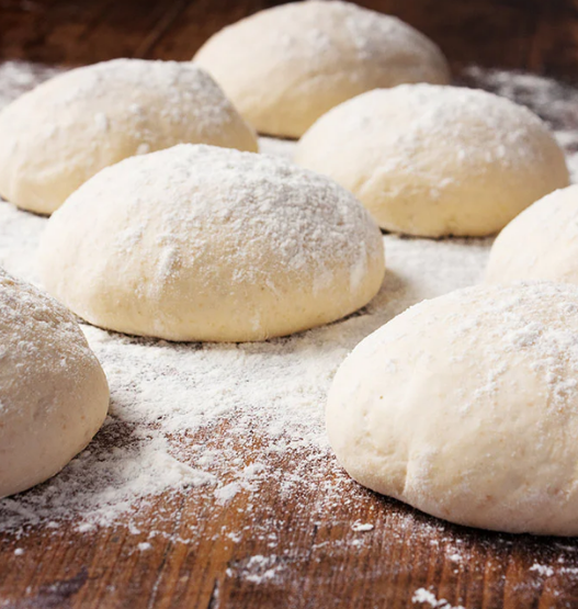 Eight individually frozen 240 g pizza dough balls arranged neatly in clear packaging.