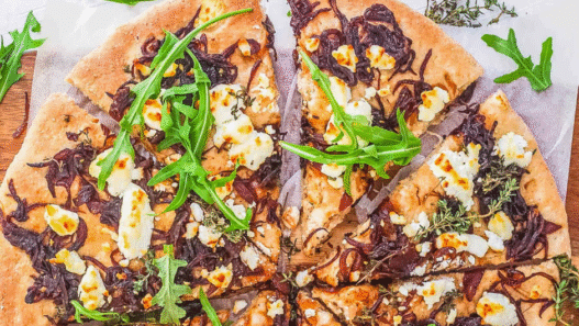 Freshly baked Caramelized Onion & Goat Cheese Pizza topped with thyme on a golden crust
