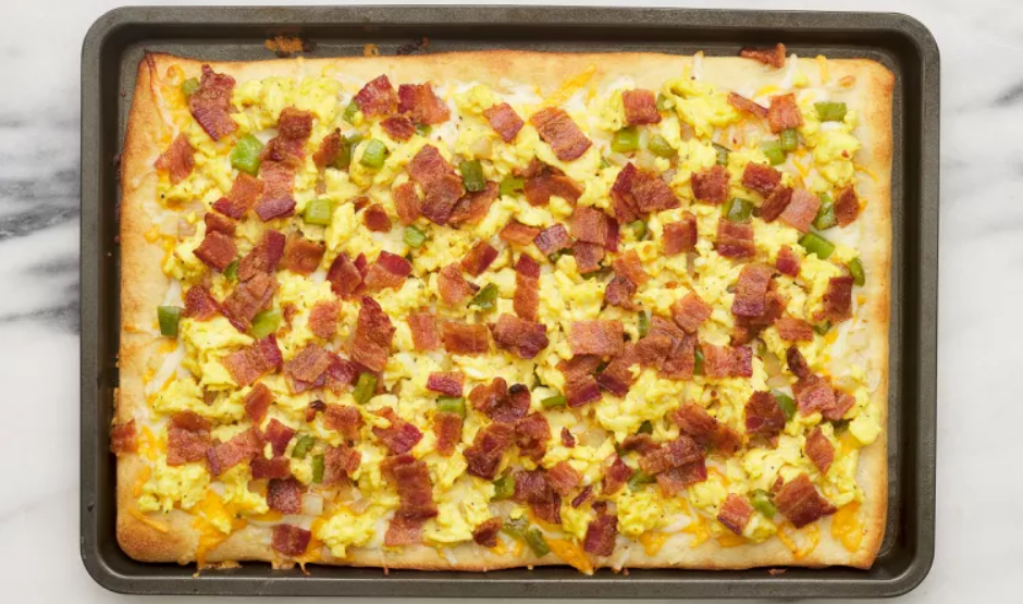 Chorizo breakfast pizza topped with roasted potatoes, sunny-side eggs, and cilantro on a golden crust