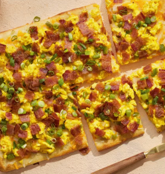 Chorizo breakfast pizza topped with roasted potatoes, sunny-side eggs, and cilantro on a golden crust