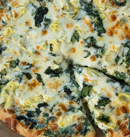 Grilled artichoke and spinach pizza with feta and mozzarella on a golden crust, served on a wooden board – inspired by Venice Beach flavors.