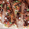 Korean BBQ beef pizza topped with bulgogi, kimchi, scallions, and gochujang aioli on a crispy crust