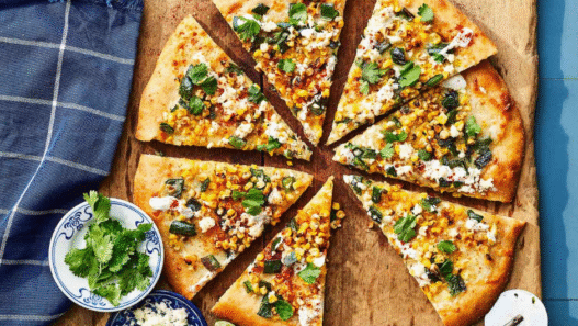 Mexican Street Corn Pizza topped with roasted corn, cotija cheese, red onion, cilantro, and chili lime crema on a golden crispy crust.