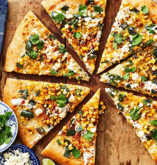 Mexican Street Corn Pizza topped with roasted corn, cotija cheese, red onion, cilantro, and chili lime crema on a golden crispy crust.