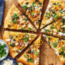 Mexican Street Corn Pizza topped with roasted corn, cotija cheese, red onion, cilantro, and chili lime crema on a golden crispy crust.