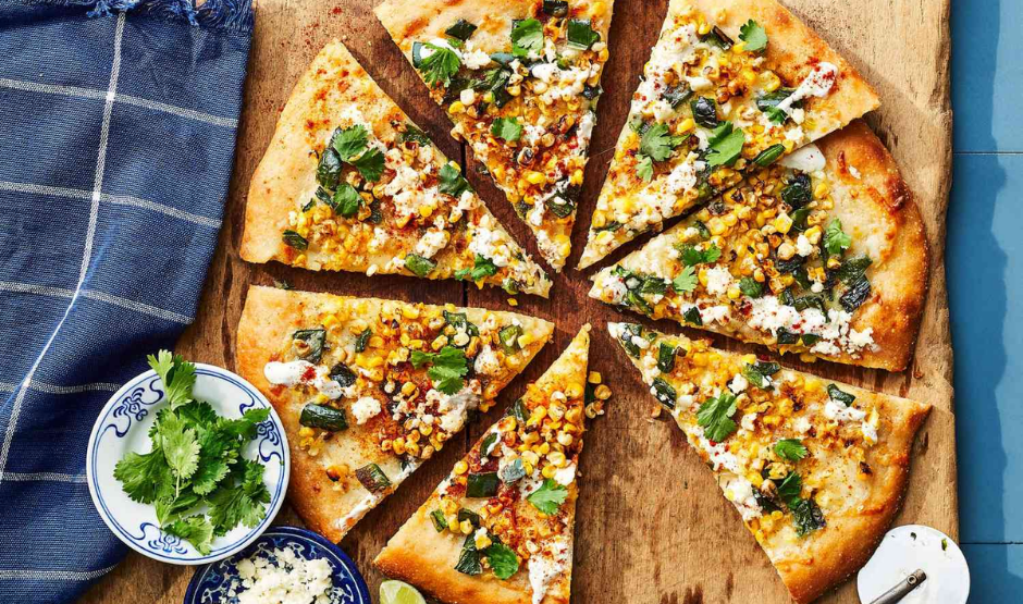 Mexican Street Corn Pizza topped with roasted corn, cotija cheese, red onion, cilantro, and chili lime crema on a golden crispy crust.