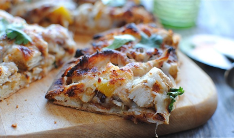 Tandoori chicken naan pizza topped with mozzarella cheese, red onions, and fresh cilantro