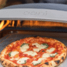 Freshly baked Neapolitan pizza on Ooni oven in backyard setting